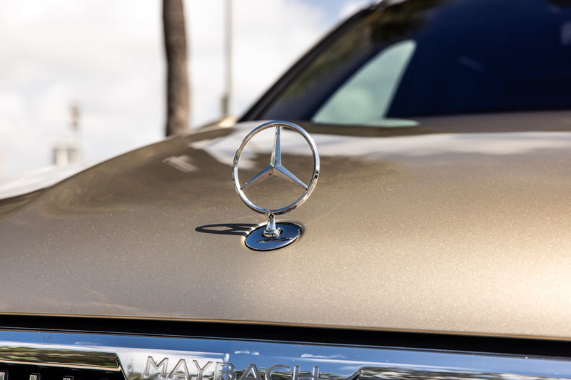 Mercedes-Benz emblem on a car hood with a blurred background