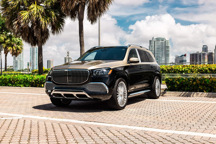 Mercedes Maybach GLS 600 parked on a paved area with palm trees and buildings in the background
