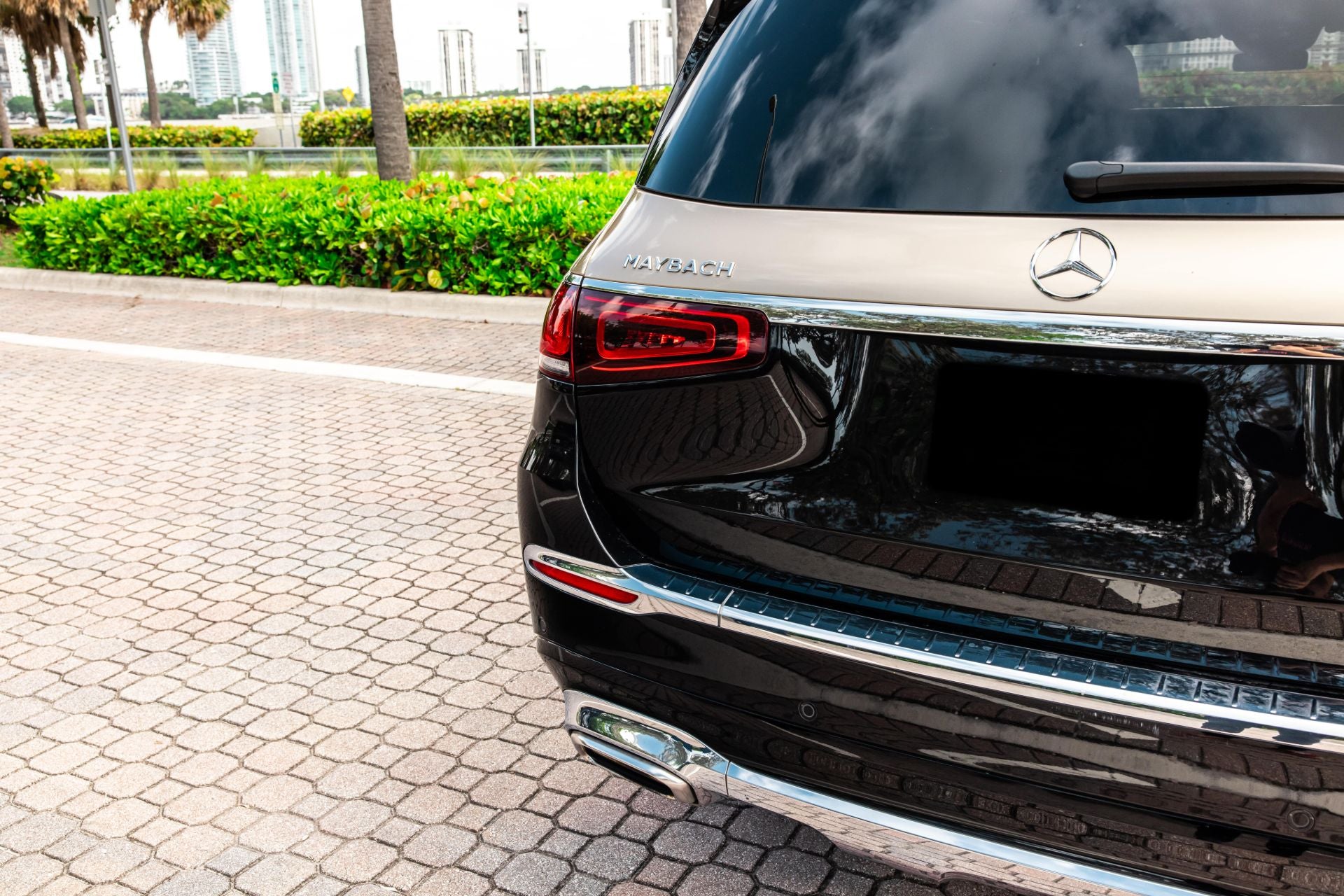 Black and Gold Mercedes Maybach GLS600 on a paved road with greenery in the background