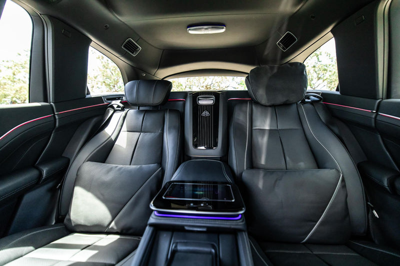 Mercedes Maybach GLS600 rear seat interior with black leather seats and a central console.