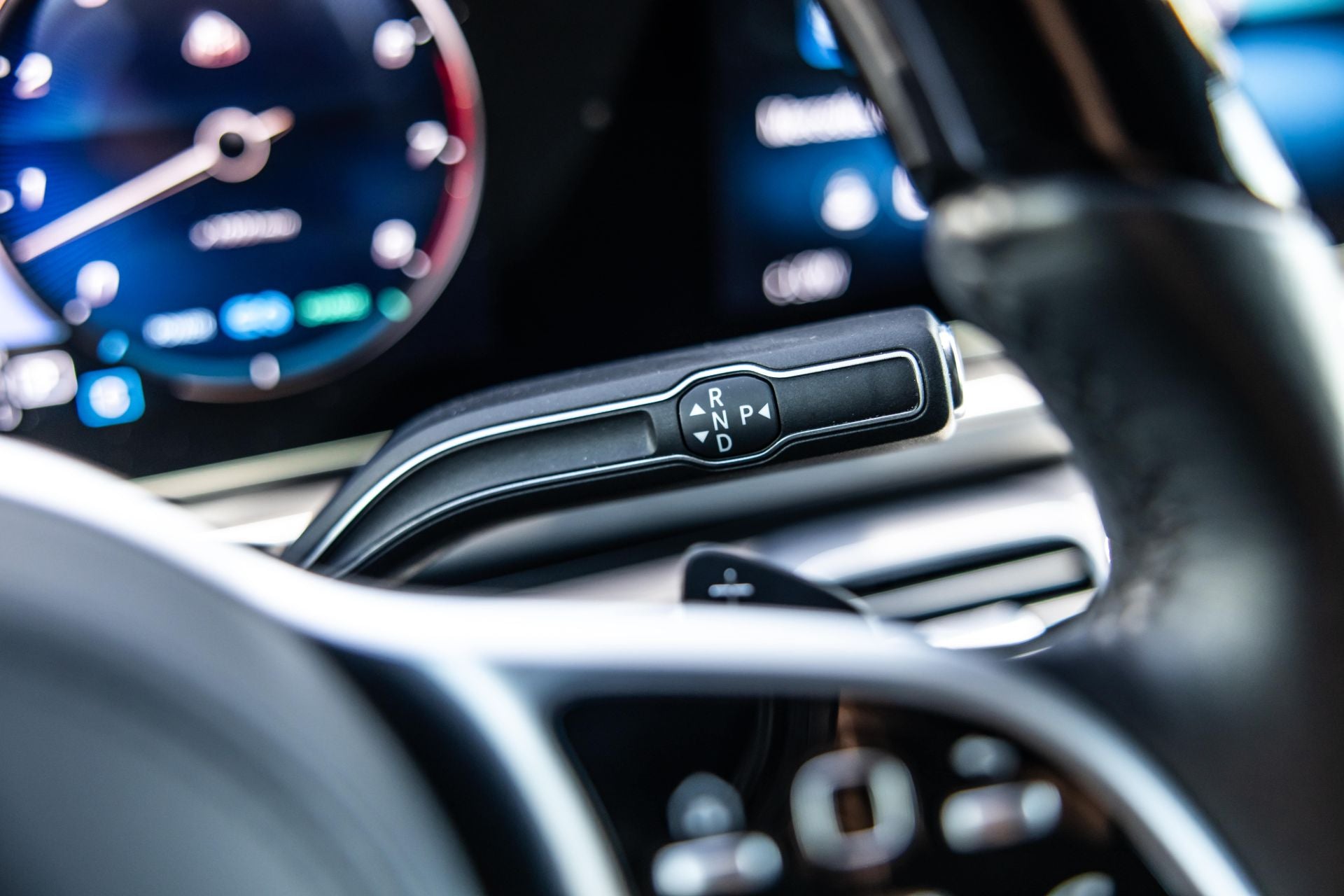 Close-up of a Mercedes Maybach GLS600 gear shift lever and dashboard with illuminated gauges.